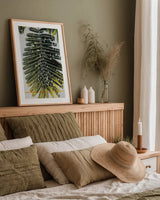 Single Palm by Deborah Revell. shown as a paper print in a natural frame. Available as a archival giclee rolled canvas, fine art paper, or poster print. SKU 91856h.