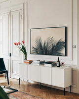 Tropical Palm II by Deborah Revell. shown as a framed stretched canvas in a living room above a console. Available as a archival giclee rolled canvas, fine art paper, or poster print. SKU 104963i.