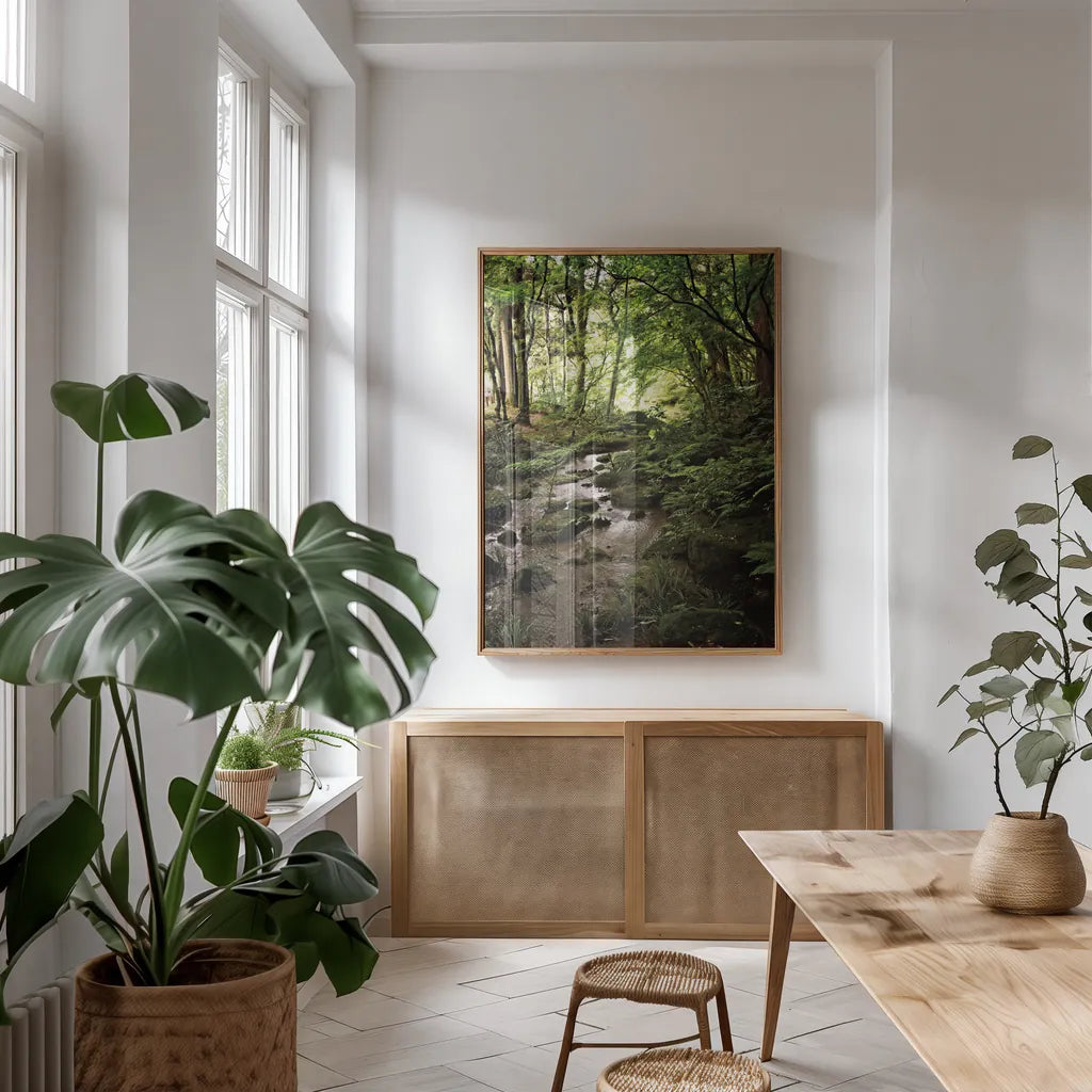 Lush Creek in Forest by Debra Van Swearingen. shown as a print in a natural wood frame in a dining room. Available as a archival giclee rolled canvas, fine art paper, or poster print. SKU 55152h.