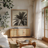 Palm Tree Sepia I by Debra Van Swearingen. Shown in a natural wood frame in a cozy modern living room. Available as an archival giclee rolled canvas, fine art paper, or poster print. SKU 42499a.