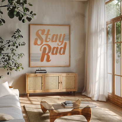 Stay Rad I Warm by Dina June. Shown in a natural wood frame in a cozy modern living room. Available as an archival giclee rolled canvas, fine art paper, or poster print. SKU 66918a.