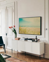 Beach Grass V by Elizabeth Urquhart. shown as a framed stretched canvas in a living room above a console. Available as a archival giclee rolled canvas, fine art paper, or poster print. SKU 25865i.