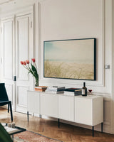 Beach Grass V Light by Elizabeth Urquhart. shown as a framed stretched canvas in a living room above a console. Available as a archival giclee rolled canvas, fine art paper, or poster print. SKU 71694i.