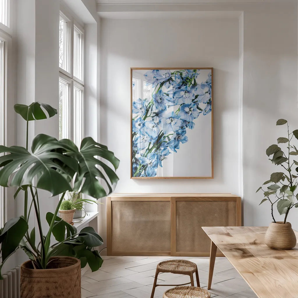 Freshly Picked Delphinium IV by Elizabeth Urquhart. shown as a print in a natural wood frame in a dining room. Available as a archival giclee rolled canvas, fine art paper, or poster print. SKU 67969h.