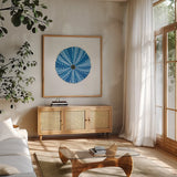 Navy Circular Shell by Emily Adams. Shown in a natural wood frame in a cozy modern living room. Available as an archival giclee rolled canvas, fine art paper, or poster print. SKU 23465a.