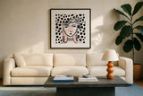 Pretty Faces I Pink by Farida Zaman. Displayed in a glass frame with matte in a clean modern living room. Available as an archival giclee rolled canvas, fine art paper, or poster print. SKU 67611a.