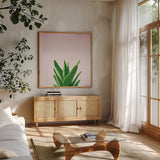 Succulent Simplicity V on Pink by Felicity Bradley. Shown in a natural wood frame in a cozy modern living room. Available as an archival giclee rolled canvas, fine art paper, or poster print. SKU 34350a.