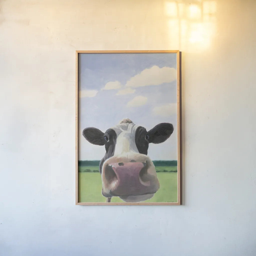 Funny Cow by James Wiens. shown as a paper print in a natural frame. Available as a archival giclee rolled canvas, fine art paper, or poster print. SKU 76092h.