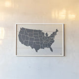 Peace and Lodge USA Map Gray by Janelle Penner. shown as a paper print in a white frame. Available as a archival giclee rolled canvas, fine art paper, or poster print. SKU 88477i.
