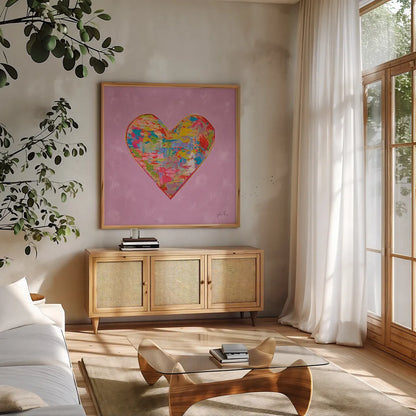 First Love on Pink by Jeanette Vertentes. Shown in a natural wood frame in a cozy modern living room. Available as an archival giclee rolled canvas, fine art paper, or poster print. SKU 78560a.