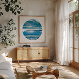 By the Sea Circle by Jess Aiken. Shown in a natural wood frame in a cozy modern living room. Available as an archival giclee rolled canvas, fine art paper, or poster print. SKU 53951a.