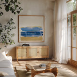 By the Sea I Blue by Jess Aiken. Shown in a natural wood frame in a cozy modern living room. Available as an archival giclee rolled canvas, fine art paper, or poster print. SKU 93884a.