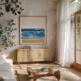 By the Sea II Blue by Jess Aiken. Shown in a natural wood frame in a cozy modern living room. Available as an archival giclee rolled canvas, fine art paper, or poster print. SKU 93885a.