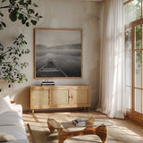 Calm Waters Canoe I BW by Jess Aiken. Shown in a natural wood frame in a cozy modern living room. Available as an archival giclee rolled canvas, fine art paper, or poster print. SKU 83655a.