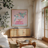 Flower Vases and Books Square Pink by Jocelyn Elizabeth. Shown in a natural wood frame in a cozy modern living room. Available as an archival giclee rolled canvas, fine art paper, or poster print. SKU 100971a.