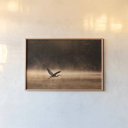 Heron in Flight by Jocelyn Elizabeth. shown as a paper print in a natural frame. Available as a archival giclee rolled canvas, fine art paper, or poster print. SKU 94029i.