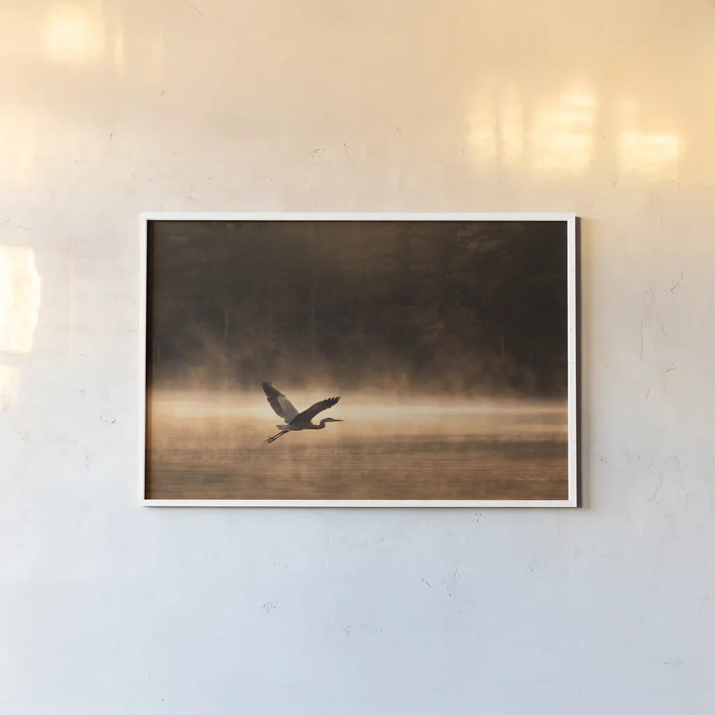 Heron in Flight by Jocelyn Elizabeth. shown as a paper print in a white frame. Available as a archival giclee rolled canvas, fine art paper, or poster print. SKU 94029i.