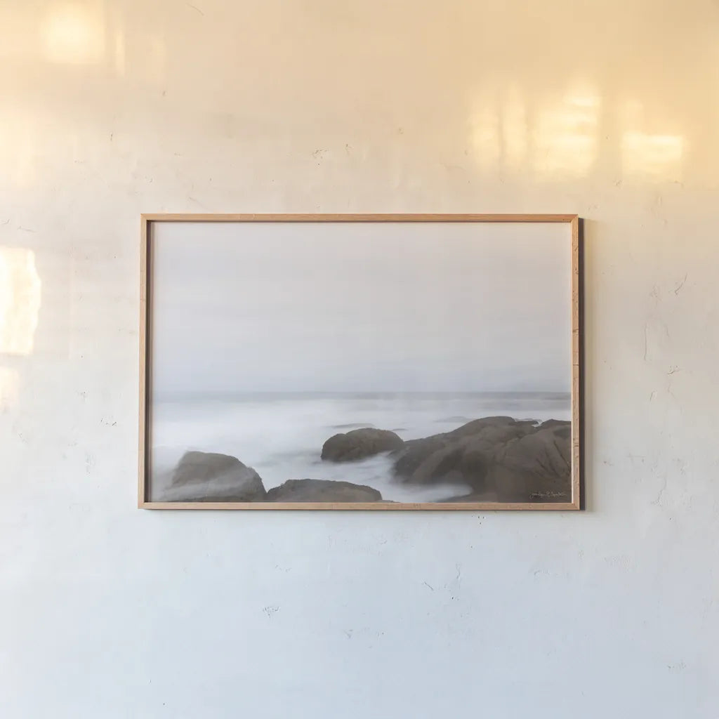 Misty Shore on the Rocks by Jocelyn Elizabeth. shown as a paper print in a natural frame. Available as a archival giclee rolled canvas, fine art paper, or poster print. SKU 100324i.