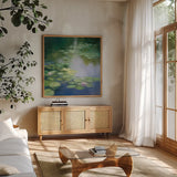 Blue Lily I by Julia Purinton. Shown in a natural wood frame in a cozy modern living room. Available as an archival giclee rolled canvas, fine art paper, or poster print. SKU 22437a.
