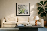 Cleome Splash II Black by Julia Purinton. Displayed in a glass frame with matte in a clean modern living room. Available as an archival giclee rolled canvas, fine art paper, or poster print. SKU 56965a.
