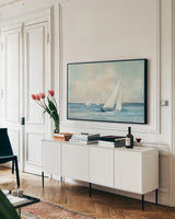 Sailboats at Sunrise by Julia Purinton. shown as a framed stretched canvas in a living room above a console. Available as a archival giclee rolled canvas, fine art paper, or poster print. SKU 62632i.