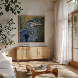 Blue Heron Backlit in Morning by Kate Jarvik Birch. Shown in a natural wood frame in a cozy modern living room. Available as an archival giclee rolled canvas, fine art paper, or poster print. SKU 98608a.