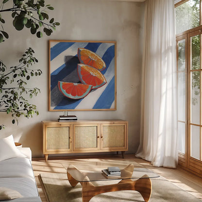 Three Citrus Slices by Kate Jarvik Birch. Shown in a natural wood frame in a cozy modern living room. Available as an archival giclee rolled canvas, fine art paper, or poster print. SKU 100964a.