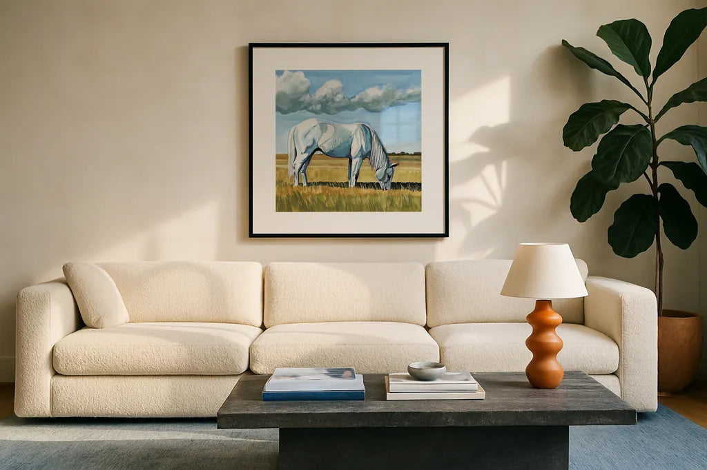 White Horse Grazing by Kate Jarvik Birch. Displayed in a glass frame with matte in a clean modern living room. Available as an archival giclee rolled canvas, fine art paper, or poster print. SKU 100957a.