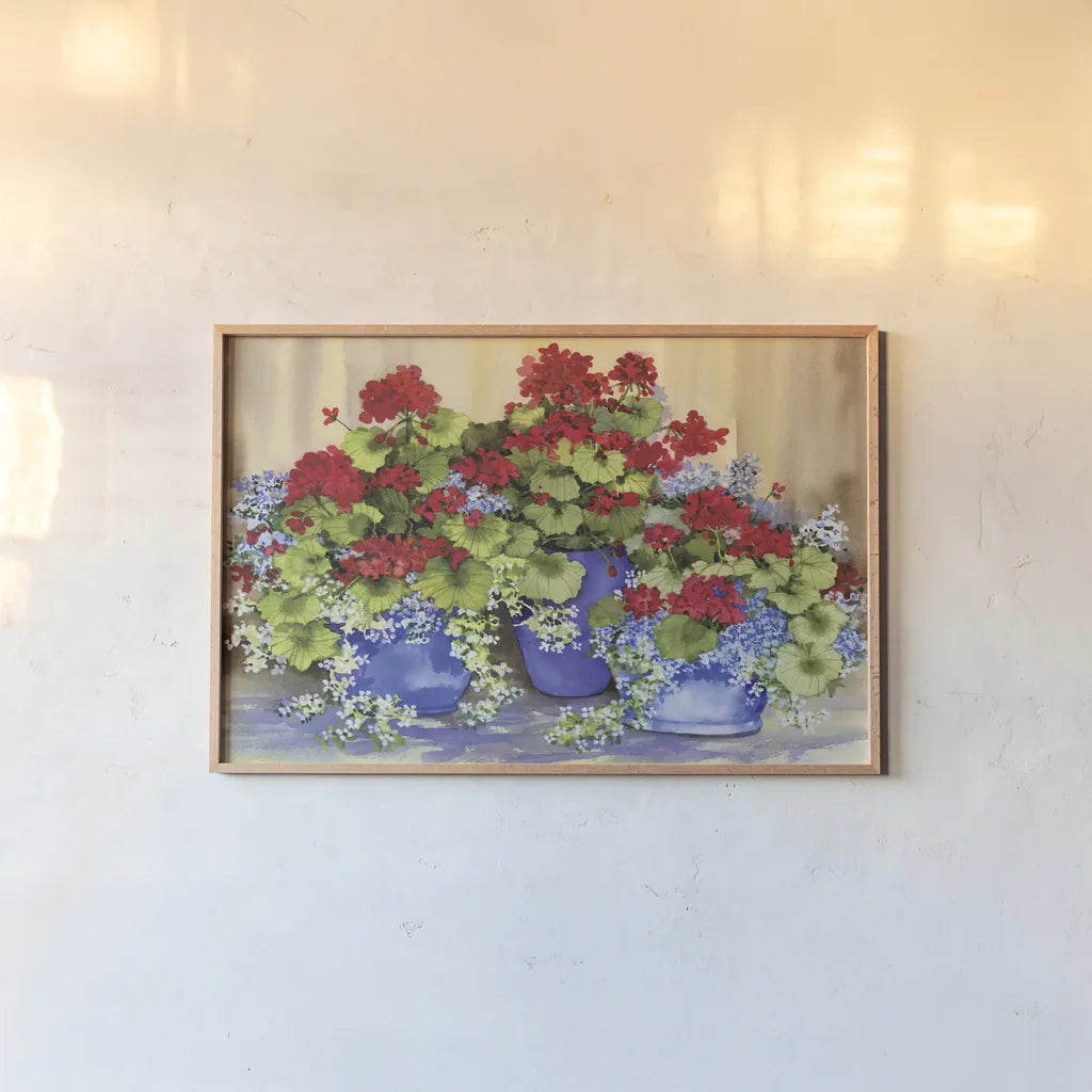 Red Geraniums with The Blues by Kathleen Parr McKenna. shown as a paper print in a natural frame. Available as a archival giclee rolled canvas, fine art paper, or poster print. SKU 88422i.