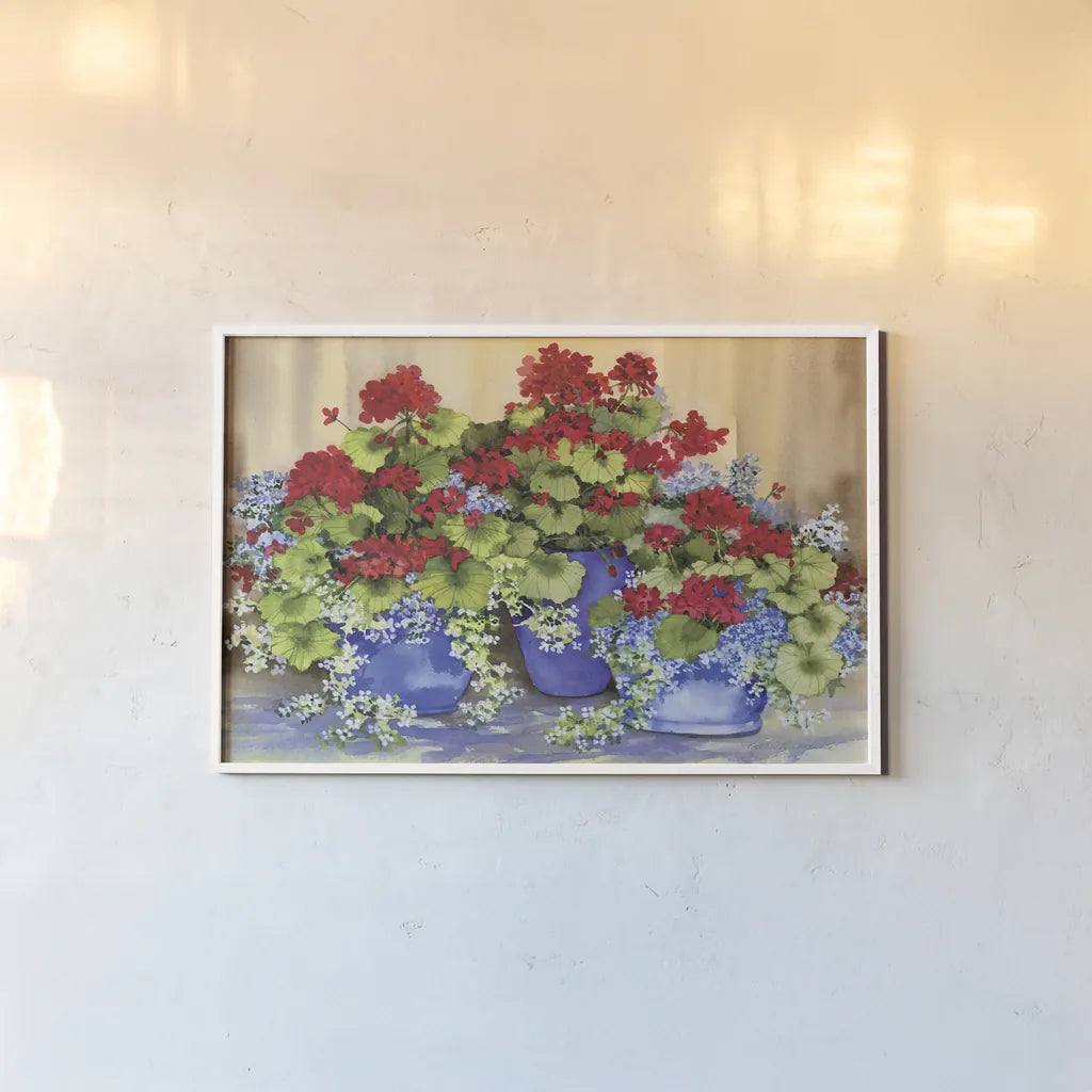 Red Geraniums with The Blues by Kathleen Parr McKenna. shown as a paper print in a white frame. Available as a archival giclee rolled canvas, fine art paper, or poster print. SKU 88422i.