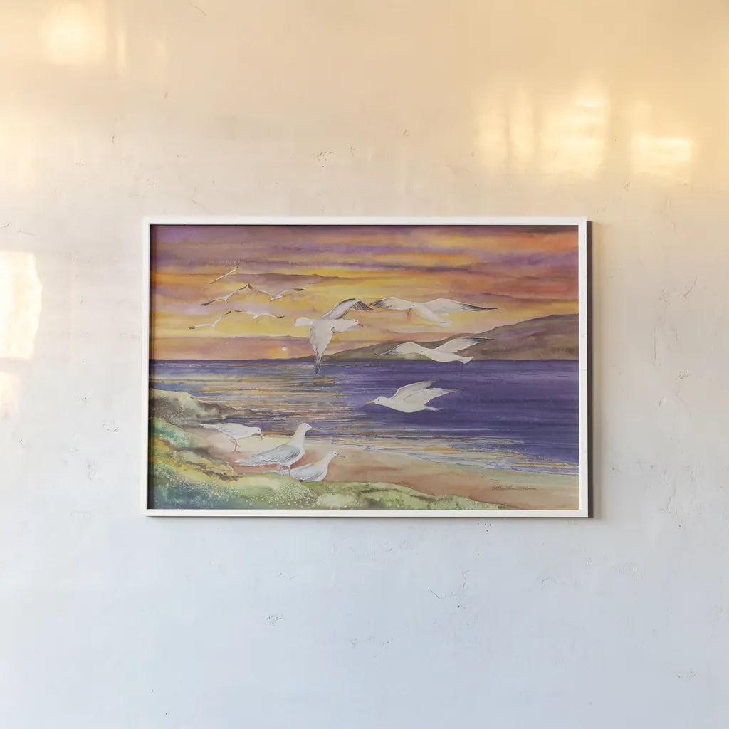 Seagull Sunset by Kathleen Parr McKenna. shown as a paper print in a white frame. Available as a archival giclee rolled canvas, fine art paper, or poster print. SKU 47973i.