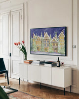 Village Christmas by Kathleen Parr McKenna. shown as a framed stretched canvas in a living room above a console. Available as a archival giclee rolled canvas, fine art paper, or poster print. SKU 41394i.