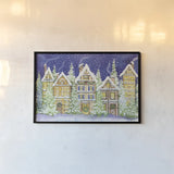 Village Christmas by Kathleen Parr McKenna. shown as a paper print in a black flame. Available as a archival giclee rolled canvas, fine art paper, or poster print. SKU 41394i.