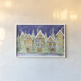 Village Christmas by Kathleen Parr McKenna. shown as a paper print in a white frame. Available as a archival giclee rolled canvas, fine art paper, or poster print. SKU 41394i.