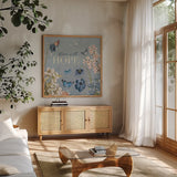 Flutter and Bloom IV Blue by Katie Pertiet. Shown in a natural wood frame in a cozy modern living room. Available as an archival giclee rolled canvas, fine art paper, or poster print. SKU 98804a.