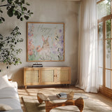 Blooming Bunnies III Hoppy by Katrina Pete. Shown in a natural wood frame in a cozy modern living room. Available as an archival giclee rolled canvas, fine art paper, or poster print. SKU 89677a.