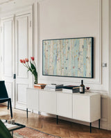 Far From Blue III Gold Leaves by Kellie Day. shown as a framed stretched canvas in a living room above a console. Available as a archival giclee rolled canvas, fine art paper, or poster print. SKU 24848i.