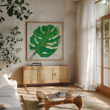 Single Leaf Play on White by Kellie Day. Shown in a natural wood frame in a cozy modern living room. Available as an archival giclee rolled canvas, fine art paper, or poster print. SKU 28279a.