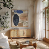 Leaves and Stones II by Laura Horn. Shown in a natural wood frame in a cozy modern living room. Available as an archival giclee rolled canvas, fine art paper, or poster print. SKU 78484a.