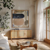 Leaves and Stones III by Laura Horn. Shown in a natural wood frame in a cozy modern living room. Available as an archival giclee rolled canvas, fine art paper, or poster print. SKU 78485a.