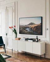 Above Skogafoss by Laura Marshall. shown as a framed stretched canvas in a living room above a console. Available as a archival giclee rolled canvas, fine art paper, or poster print. SKU 69903i.