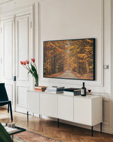 Autumn Country Road by Laura Marshall. shown as a framed stretched canvas in a living room above a console. Available as a archival giclee rolled canvas, fine art paper, or poster print. SKU 16683i.