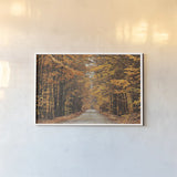 Autumn Country Road by Laura Marshall. shown as a paper print in a white frame. Available as a archival giclee rolled canvas, fine art paper, or poster print. SKU 16683i.