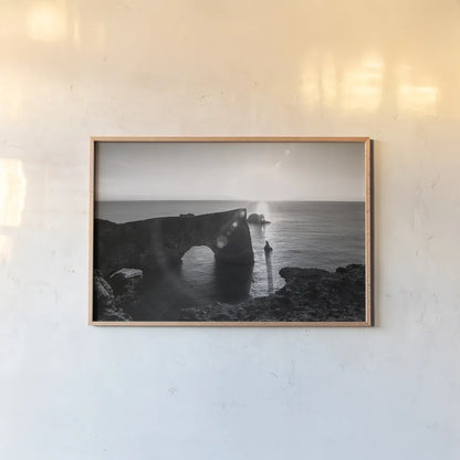 Dyrholaey by Laura Marshall. shown as a paper print in a natural frame. Available as a archival giclee rolled canvas, fine art paper, or poster print. SKU 64398i.