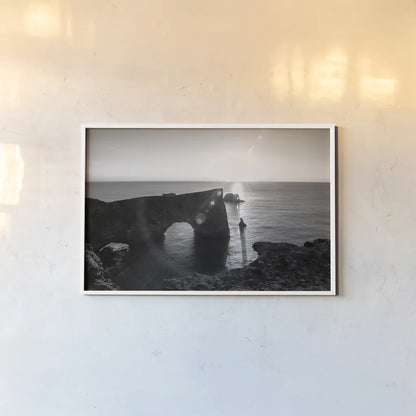 Dyrholaey by Laura Marshall. shown as a paper print in a white frame. Available as a archival giclee rolled canvas, fine art paper, or poster print. SKU 64398i.