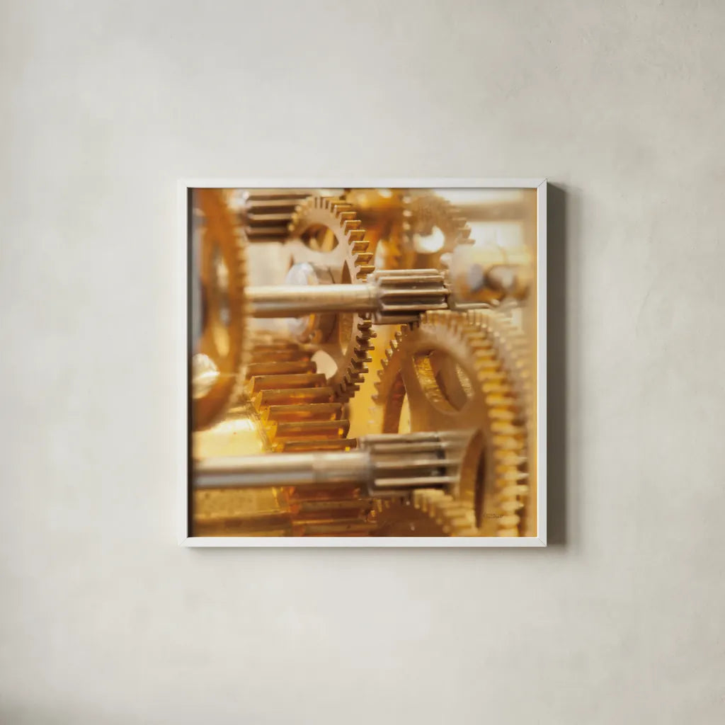 Gilded Gears I by Laura Marshall. Shown in a crisp white glass frame for a clean and minimalist style. Available as an archival giclee rolled canvas, fine art paper, or poster print. SKU 25869a.