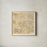 Gilded London Map by Laura Marshall. Shown in a natural wood glass frame for a timeless modern aesthetic. Available as an archival giclee rolled canvas, fine art paper, or poster print. SKU 17664a.