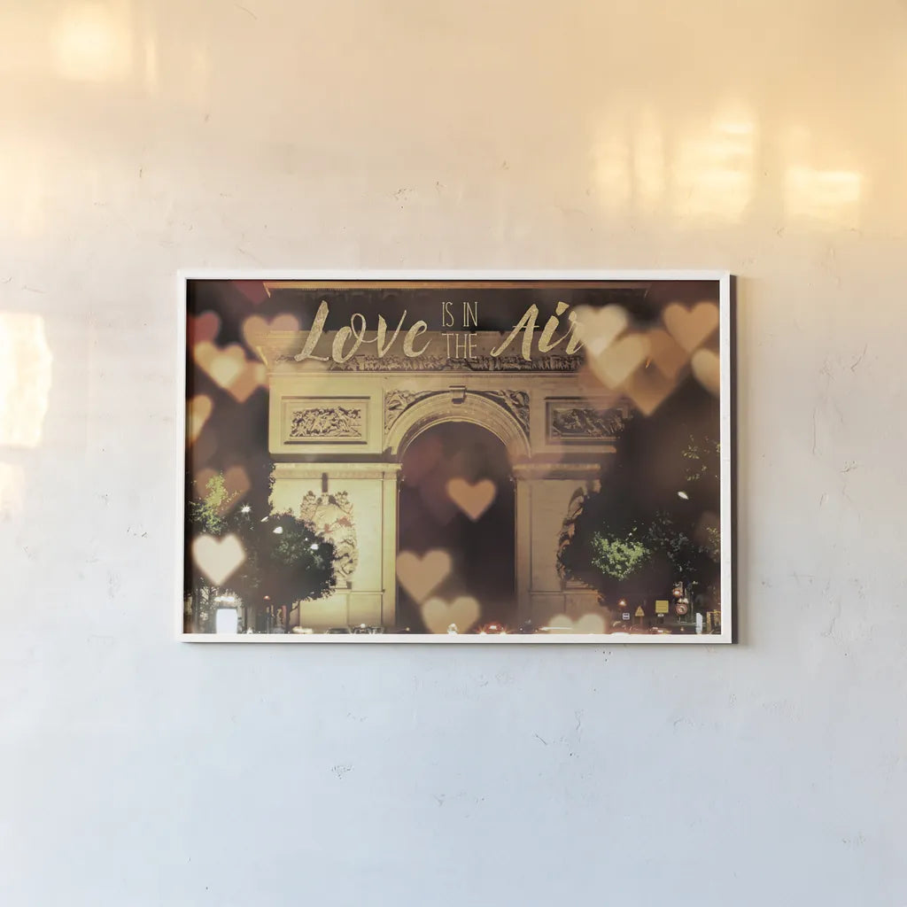 Love is in the Arc de Triomphe v2 by Laura Marshall. shown as a paper print in a white frame. Available as a archival giclee rolled canvas, fine art paper, or poster print. SKU 36980i.