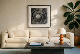 Ranunculus Abstract I BW by Laura Marshall. Displayed in a glass frame with matte in a clean modern living room. Available as an archival giclee rolled canvas, fine art paper, or poster print. SKU 25284a.