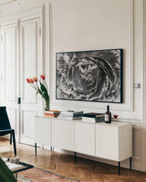 Ranunculus Abstract VI BW by Laura Marshall. shown as a framed stretched canvas in a living room above a console. Available as a archival giclee rolled canvas, fine art paper, or poster print. SKU 25289i.